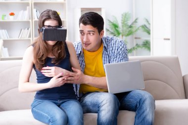 Genç bir aile sanal gerçeklik gözlükleriyle oyun oynuyor.