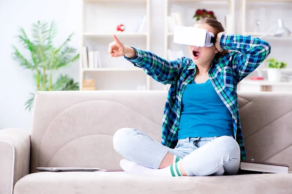 Vrouwelijke student zittend op de bank met virtuele bril — Stockfoto