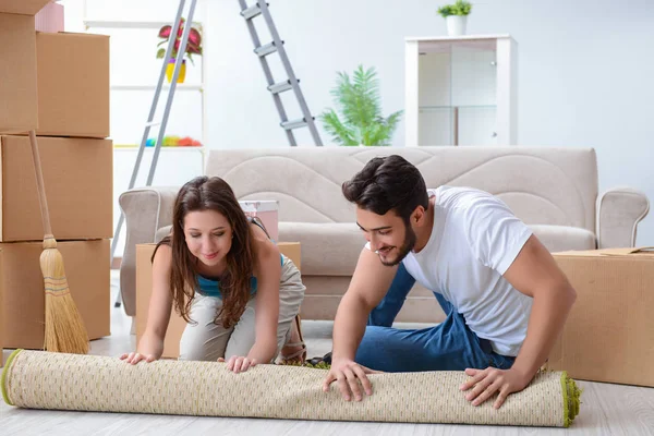 Familia joven desempacando en casa nueva con cajas —  Fotos de Stock