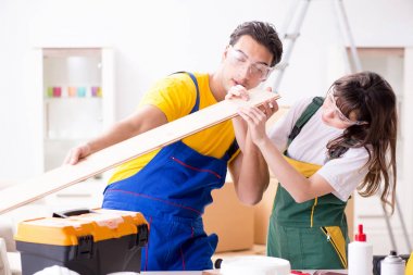 Ahşap atölyesinde kadın marangozluk ipuçlarını açıklayan adam