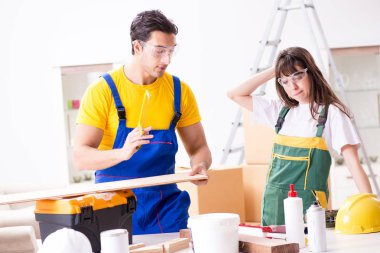 Ahşap atölyesinde kadın marangozluk ipuçlarını açıklayan adam