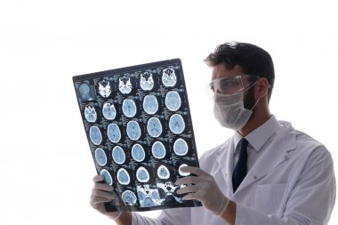 Röntgen görüntülerine bakan genç doktor beyazda izole edilmiş.