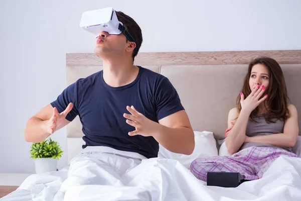 Esposa e marido com óculos de realidade virtual na cama — Fotografia de Stock