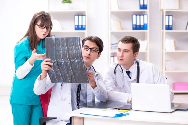Três médicos discutindo resultados de varredura de imagem de raios-x — Fotografia de Stock