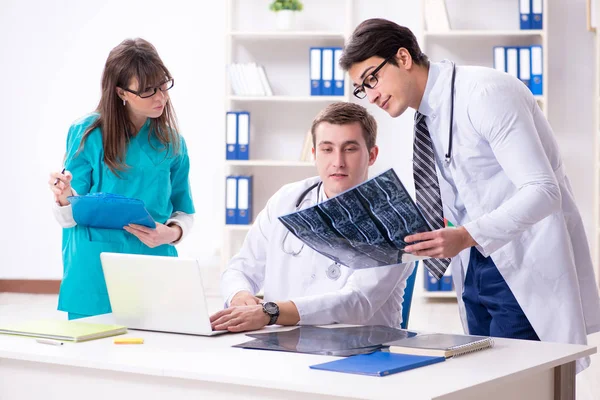 Tres médicos discutiendo los resultados de la exploración de la imagen de rayos X — Foto de Stock