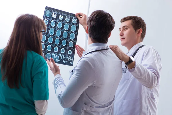 Three doctors discussing scan results of x-ray image — Stock Photo, Image