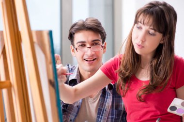 Stüdyoda resim sınıfında sanatçı koçluğu yapan bir öğrenci.