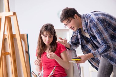 Stüdyoda resim sınıfında sanatçı koçluğu yapan bir öğrenci.