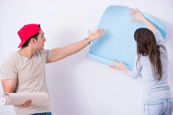 Família jovem fazendo renovação em casa com novo papel de parede — Fotografia de Stock