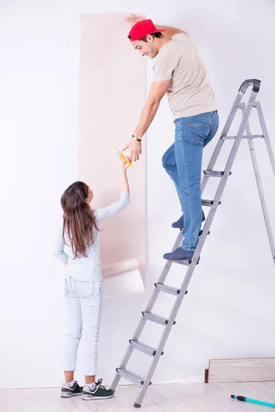 Jong gezin doet renovatie thuis met nieuw behang — Stockfoto