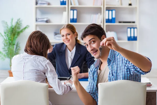 Young family agreeing mortgage contract in the bank for new house