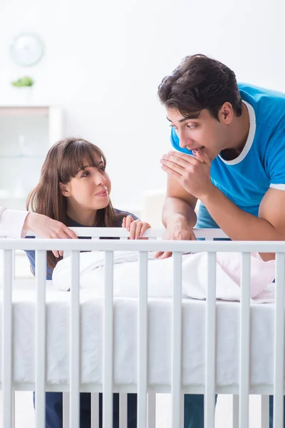 Boldog fiatal család a babaágyban kiságy — Stock Fotó
