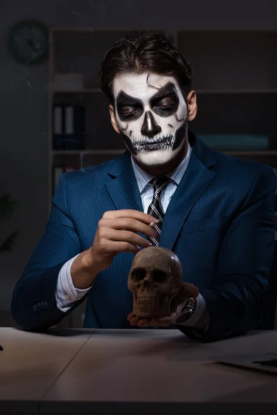 Бізнесмен з страшною маскою для обличчя, що працює пізно в офісі — стокове фото