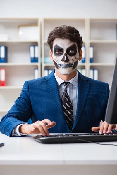 Businessmsn con maschera viso spaventoso che lavora in ufficio — Foto Stock