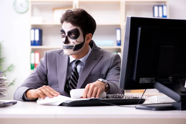 Businessmsn con maschera viso spaventoso che lavora in ufficio — Foto Stock