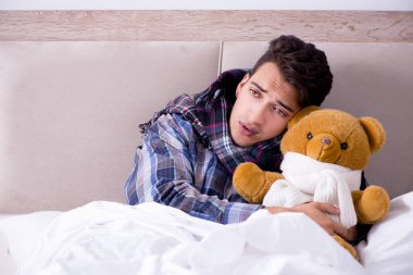 Sick man suffering from flu in the bed clipart