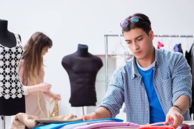 Atölyede erkek terzi ve bayan öğrenci.