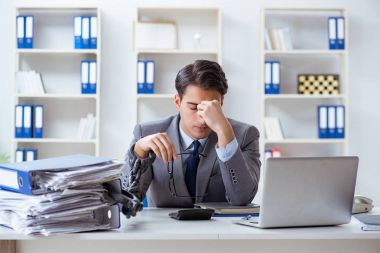 Ofis masasına zincirlenmiş meşgul bir çalışan.