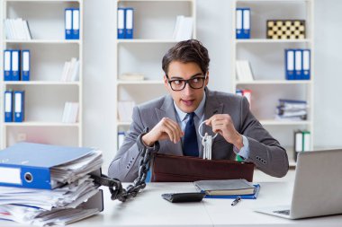 Ofis masasına zincirlenmiş meşgul bir çalışan.