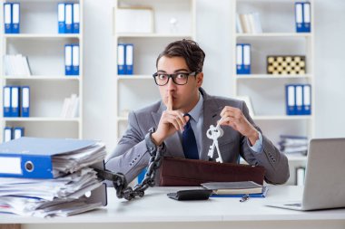 Ofis masasına zincirlenmiş meşgul bir çalışan.