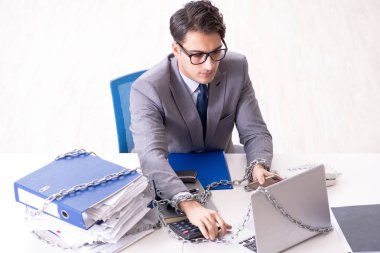Ofis masasına zincirlenmiş meşgul bir çalışan.