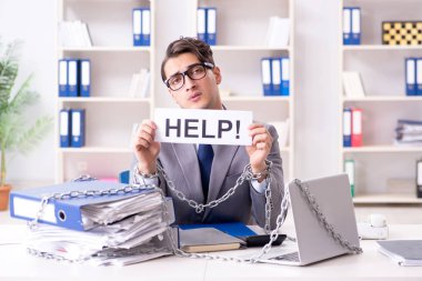 Ofis masasına zincirlenmiş meşgul bir çalışan.