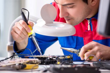 profesyonel tamirci atölyede bilgisayar tamir ediyor.
