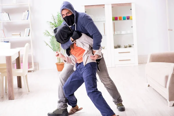 Homme armé agressant une jeune femme à la maison — Photo