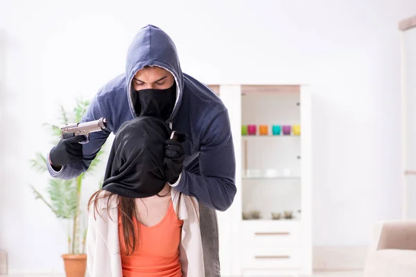 Homme armé agressant une jeune femme à la maison — Photo