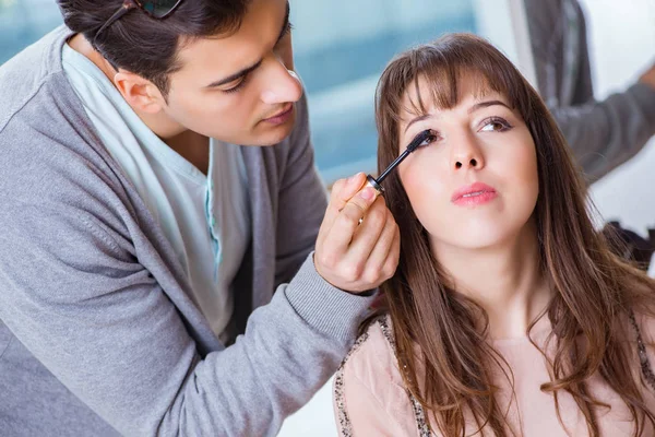 Hombre haciendo maquillaje para mujer linda en salón de belleza —  Fotos de Stock