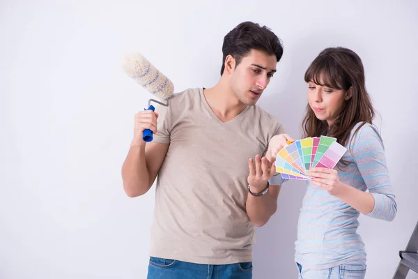 Jeune famille en rénovation à la maison - peinture de murs — Photo