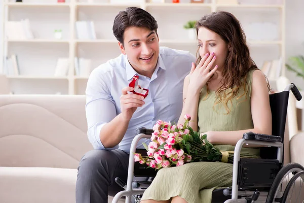 Hombre haciendo propuesta de matrimonio a mujer discapacitada en silla de ruedas — Foto de Stock