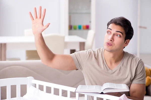 Joven estudiante de papá preparándose para los exámenes y cuidando al bebé —  Fotos de Stock