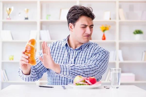 Man having dilemma between healthy food and bread in dieting con — Stock Photo, Image