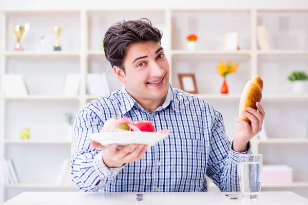 Man having dilemma between healthy food and bread in dieting con — Stock Photo, Image