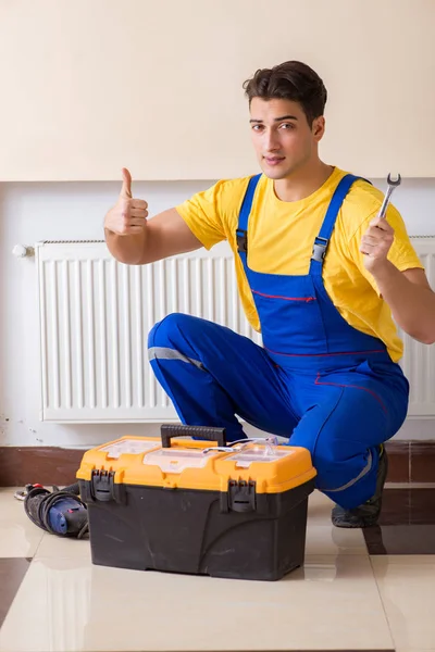 Jovem reparador contratante reparação painel de aquecimento — Fotografia de Stock