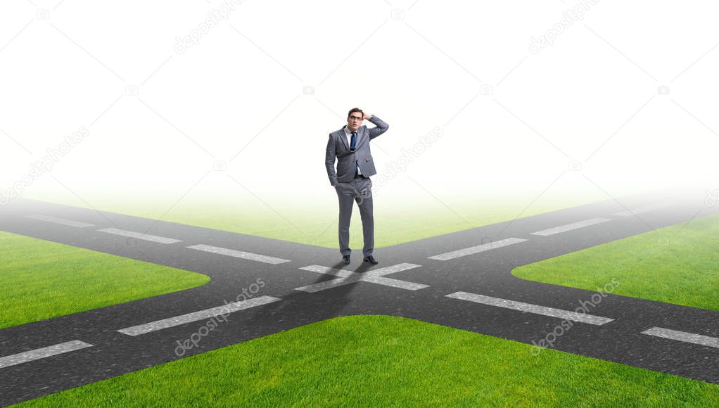 Young businessman at crossroads in uncertainty concept