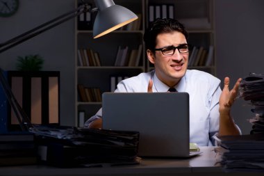 Genç işadamı geç saatlere kadar ofiste çalışıyor.