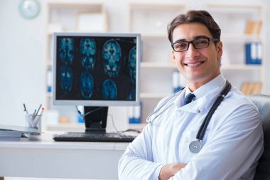 Doktor radyoloji uzmanı röntgen görüntülerine bakıyor.