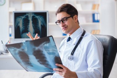 Doktor radyoloji uzmanı röntgen görüntülerine bakıyor.