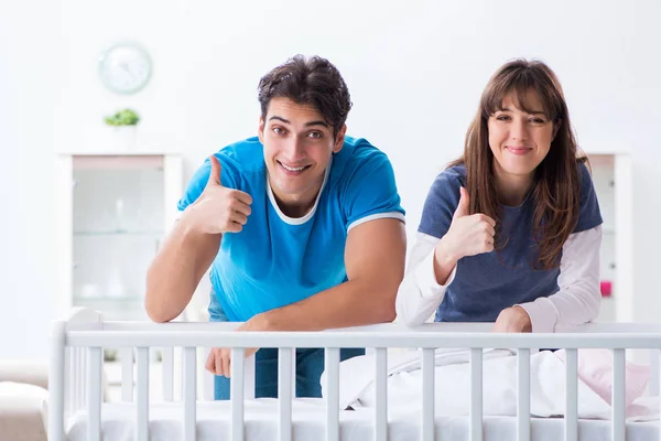 Glad ung familj vid babysäng — Stockfoto
