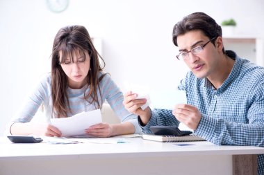 Aile mali belgelerine bakan genç bir çift.