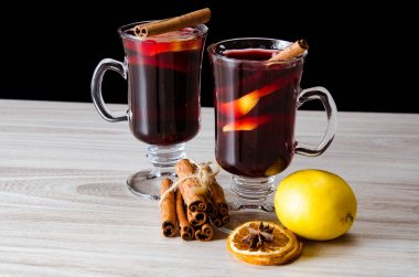 Haşlanmış şarap, yılbaşı masasında servis edilen bardaklarda parlıyor.