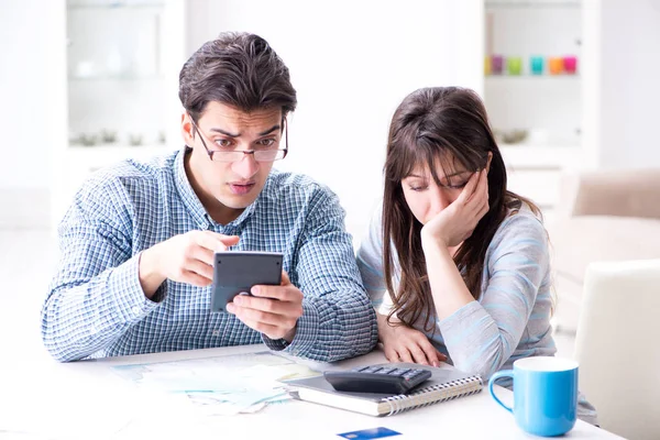 Unga par tittar på familjens ekonomi papper — Stockfoto
