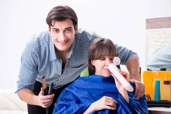 Man male hairdresser doing haircut for woman