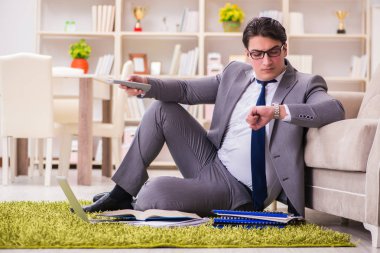 İş adamı evde yerde çalışıyor.