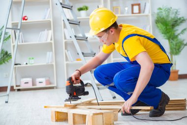 Ahşap palet montajı yapan genç adam.