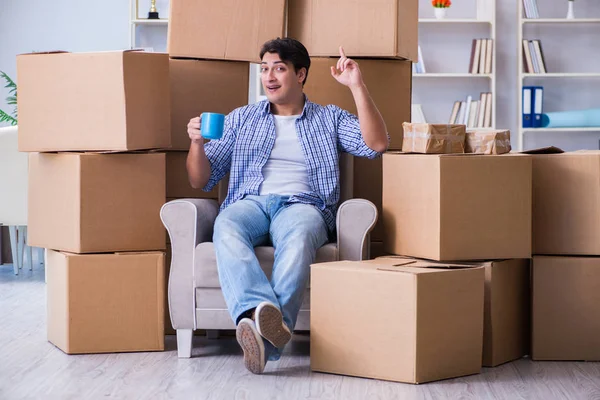 Young man moving in to new house with boxes — Stock Photo, Image