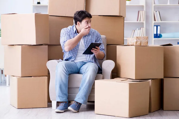 Молодий чоловік переїжджає в новий будинок з коробками — стокове фото