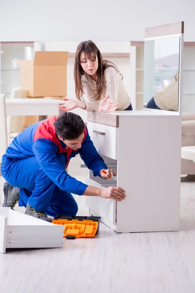 Contractor repairman assembling furniture under woman supervisio — Stock Photo, Image